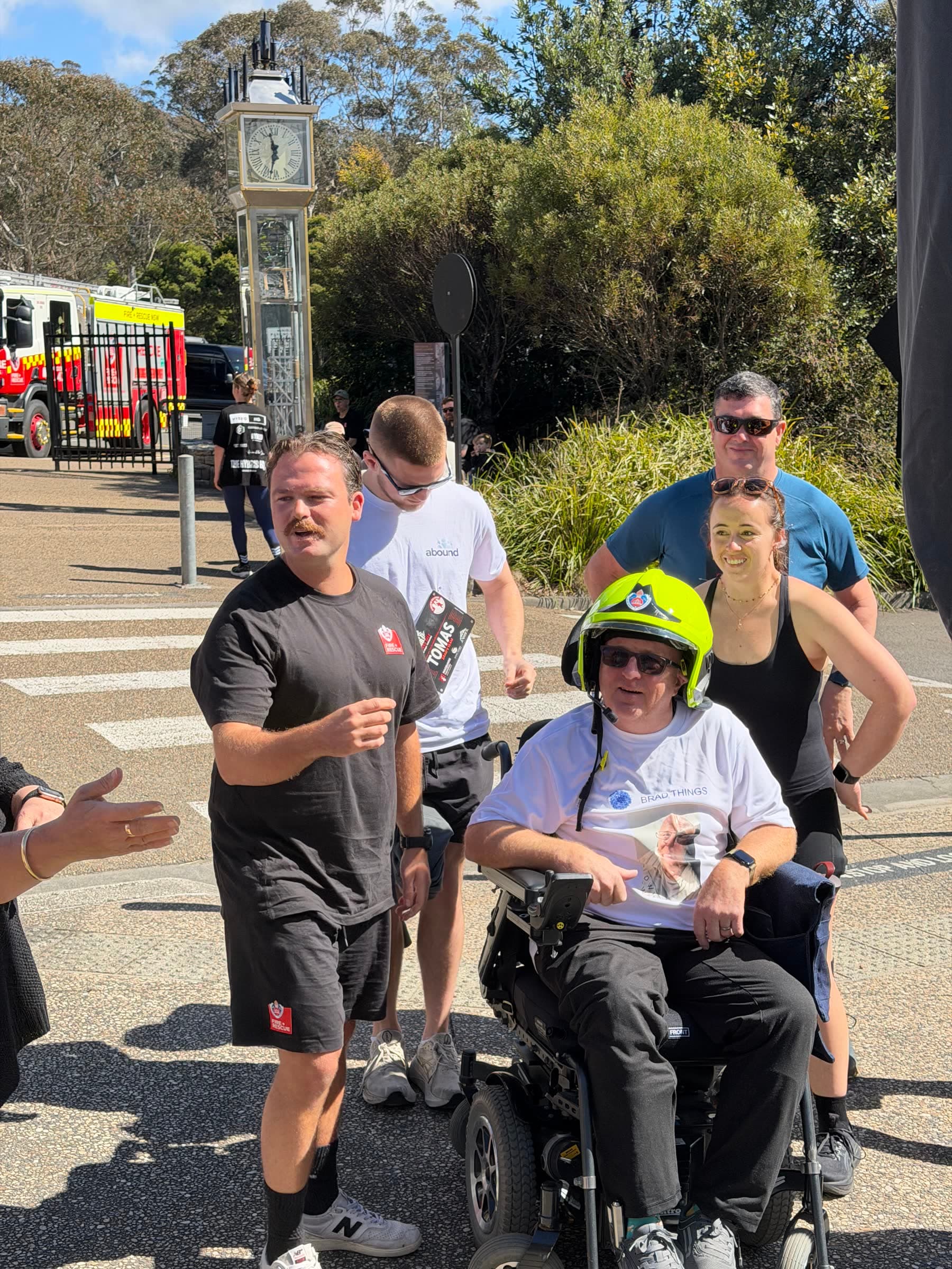 Brad wearing a firefighter helmet with Brad's Team