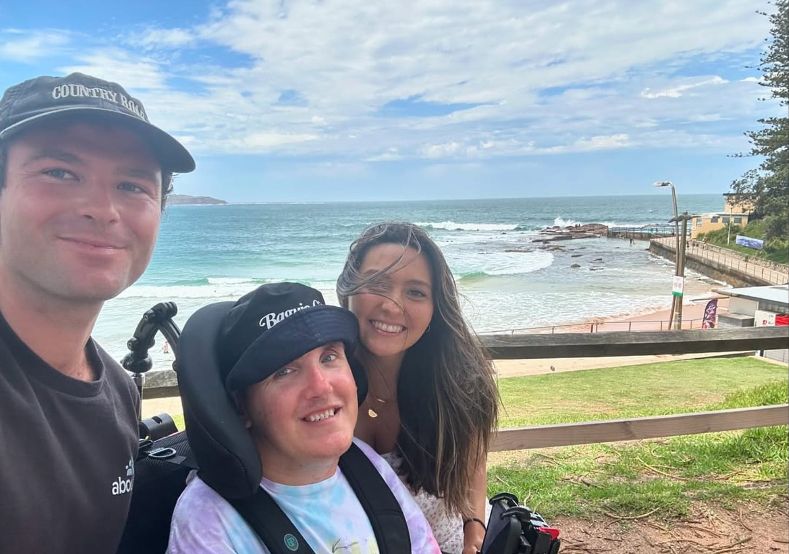Three people together beside the coast